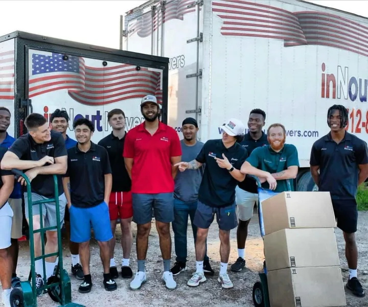 inNout Movers crew gathered in front of two branded moving trucks