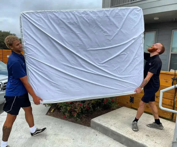 inNout Movers crew carrying a protected mattress
